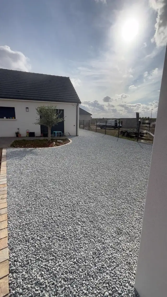 Cour gravillonnée aménagée devant une maison à Lunery