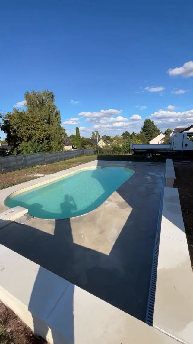 Plage de piscine en béton réalisée autour d'une piscine coque