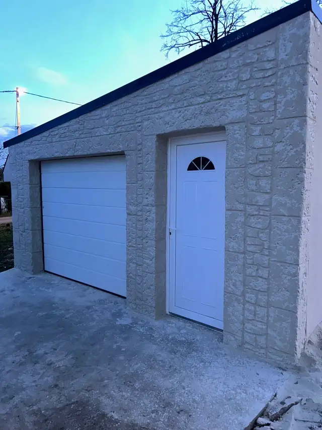 Garage avec encadrements effet pierre, porte de garage et porte d'entrée
