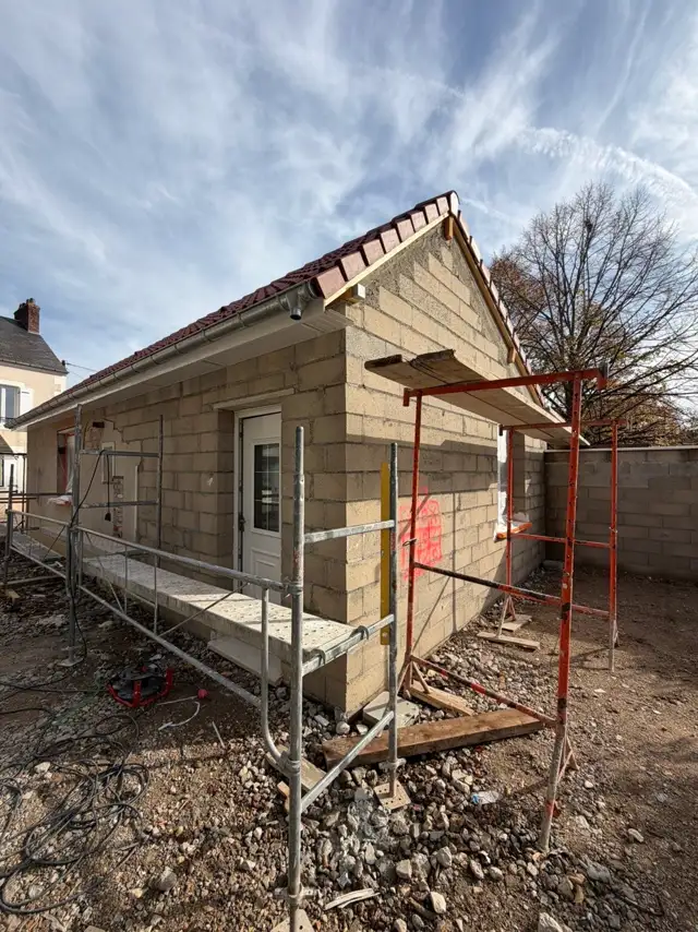 Application de l'enduit de façade sur une maison, échafaudage en place