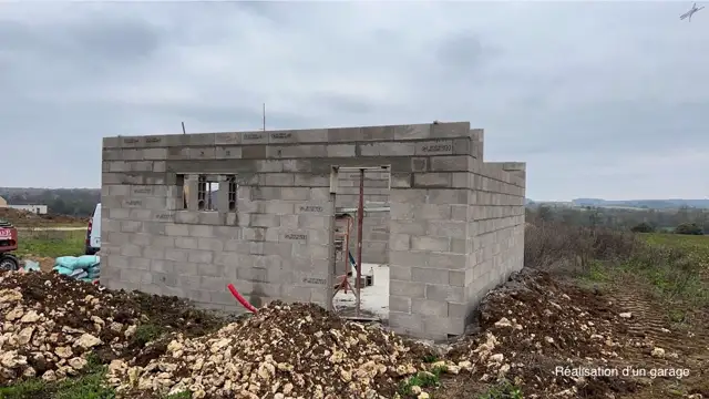 Élévation des murs en parpaings d'une construction par un maçon à Lunery