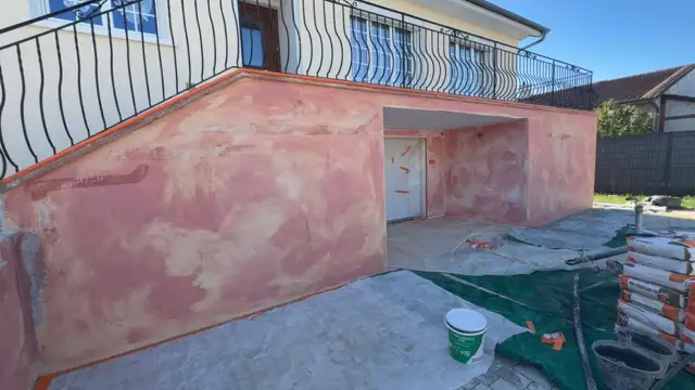 Soubassement en cours d'enduit sur un mur extérieur