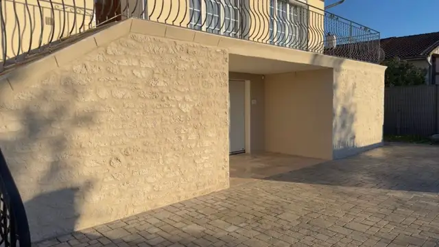 Extension enduite en beige avec cour pavée assortie