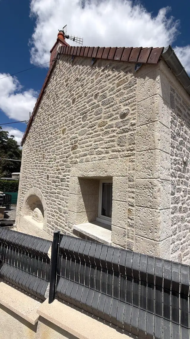 Détail d'une façade effet pierre avec fenêtre en arche